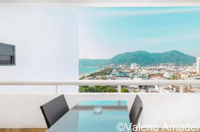 a table and chairs on a balcony with a view at Patong Tower Sea View by PHR in Patong Beach