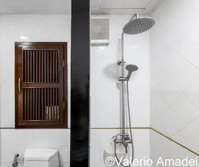 a shower in a bathroom with a toilet and a window at Patong Tower Sea View by PHR in Patong Beach
