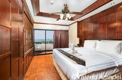 a bedroom with a large bed and a balcony at Patong Tower Sea View by PHR in Patong Beach