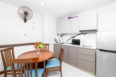 a small kitchen with a wooden table and chairs at Patong Tower Sea View by PHR in Patong Beach