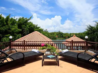 a deck with two benches and a table and a lake at Laguna Waters in Phuket Town