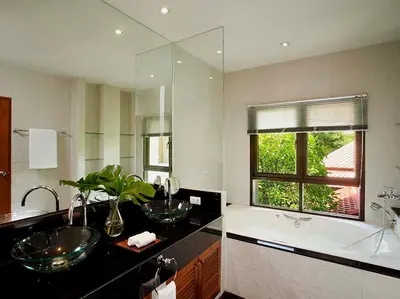 a bathroom with two sinks and a large mirror at Laguna Waters in Phuket Town