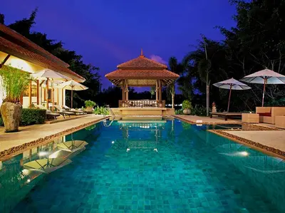 a swimming pool with a gazebo at night at Laguna Waters in Phuket Town