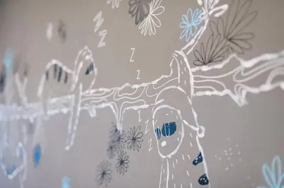 a drawing of a woman with a tree on a wall at TIRAS Patong Beach Hotel in Patong Beach