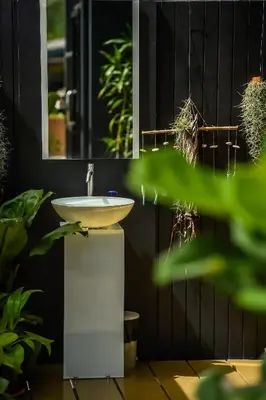 a bathroom with a sink and some plants at Dee Homestay in Ban Pa Khlok