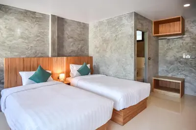 a bedroom with two beds and a bathroom at Dee Homestay in Ban Pa Khlok