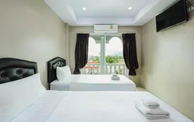 a hotel room with two beds and a window at Tyler Cherngtalay in Ban Pak Lak