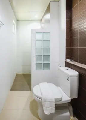 a white bathroom with a toilet and a shower at Tyler Cherngtalay in Ban Pak Lak