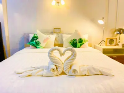 two towels in the shape of a heart on a bed at Primego Boutique Hotel in Phuket Town