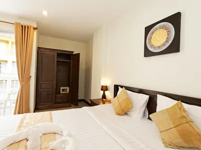 a bedroom with a bed with white sheets and pillows at Garden Phuket Hotel in Patong Beach