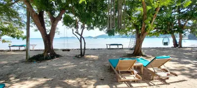 two chairs and a table on a beach at The Mooring Resort in Panwa Beach
