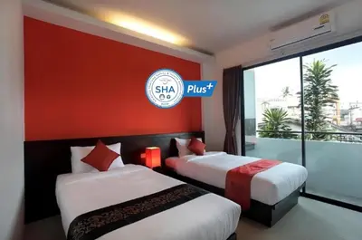 two beds in a hotel room with a sign that reads skip at KARON SINO House in Karon Beach