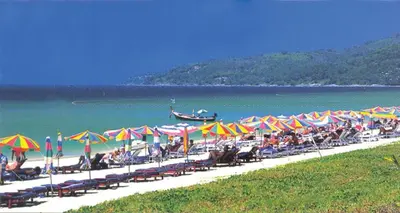 a beach with a bunch of chairs and umbrellas at KARON SINO House in Karon Beach