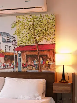 a painting on the wall above a bed in a hotel room at APARTMENTS MBC in Mai Khao Beach