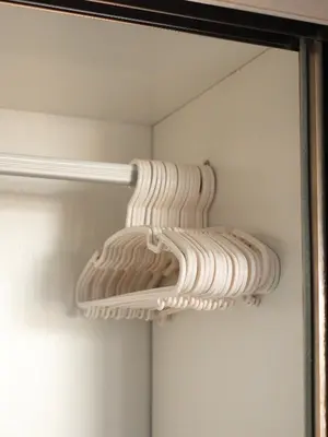 a bunch of white dishes are on a rack in a closet at APARTMENTS MBC in Mai Khao Beach