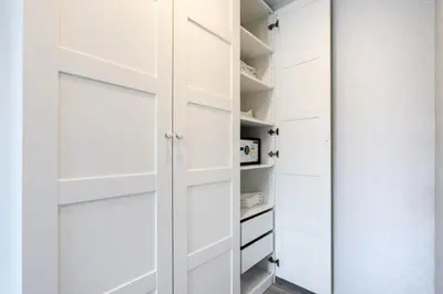 a walk in closet with white cabinets at Luxury Apartment at Title Residencies Naiyang Beach in Phuket Town