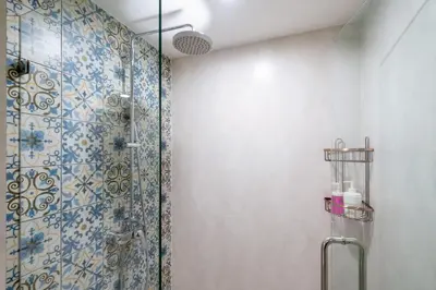 a bathroom with a shower with blue and white tiles at Luxury Apartment at Title Residencies Naiyang Beach in Phuket Town