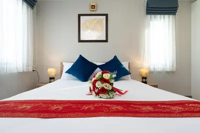 a bed with a bouquet of flowers on it at Luxury Apartment at Title Residencies Naiyang Beach in Phuket Town