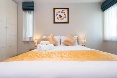 a bedroom with a large bed with a teddy bear on it at The Apartment at The Title Residencies Naiyang Beach in Phuket Town