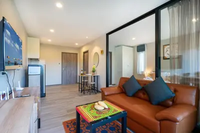 a living room with a couch and a table at The Apartment at The Title Residencies Naiyang Beach in Phuket Town