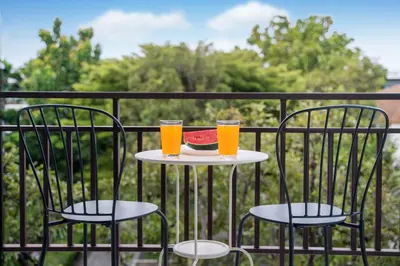 two glasses of orange juice and a plate of food on a table at The Title Rawai Beach West Wing in Phuket Town
