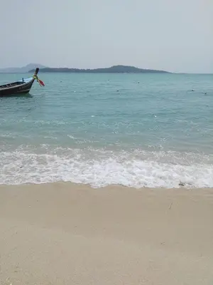 a person in a boat in the water near the beach at The Title Rawai Beach West Wing in Phuket Town