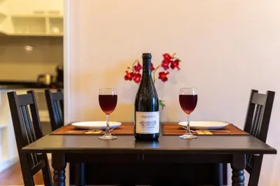 a bottle of wine sitting on a table with two glasses at The Title Rawai Beach West Wing in Phuket Town