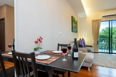 a living room with a table with two glasses of wine at The Title Rawai Beach West Wing in Phuket Town