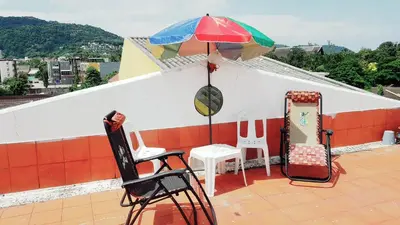 a patio with chairs and an umbrella on a roof at Kata Happy Place in Kata Beach