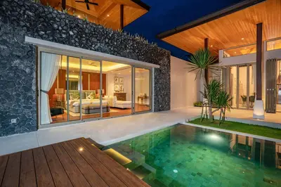 a villa with a swimming pool and a bedroom at Botanica Bangtao Beach Villa in Phuket Town