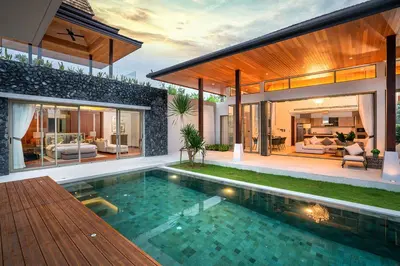 a house with a swimming pool in front of a house at Botanica Bangtao Beach Villa in Phuket Town