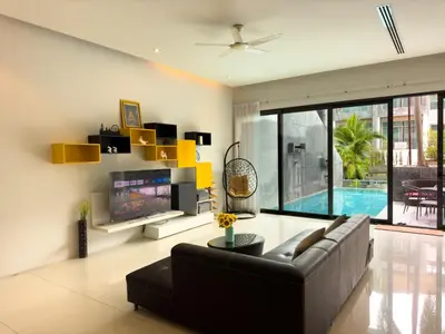 a living room with a couch and a tv at Fantastic SeaView 4br Private Pool Villa in Rawai Beach