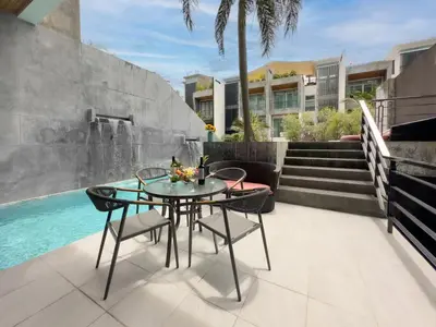 a patio with a table and chairs next to a swimming pool at Fantastic SeaView 4br Private Pool Villa in Rawai Beach