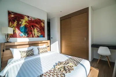 a bedroom with a bed and a painting on the wall at Cocoon Villa - Peaceful private pool villa in north Phuket in Phuket Town