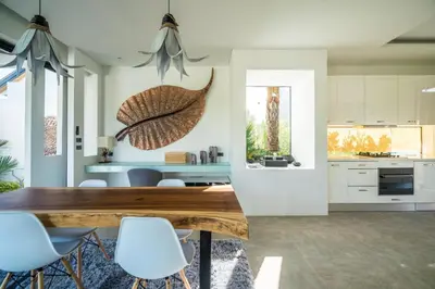 a kitchen and dining room with a wooden table and chairs at Cocoon Villa - Peaceful private pool villa in north Phuket in Phuket Town