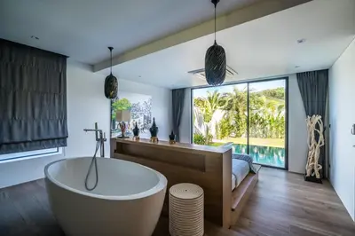 a bathroom with a tub and a large window at Cocoon Villa - Peaceful private pool villa in north Phuket in Phuket Town