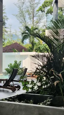 a patio with two chairs and some plants at CYAN Resort Kamala Beach Apartments Condominiums in Kamala Beach