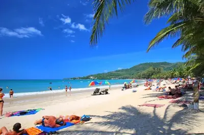 a group of people laying on a beach at CYAN Resort Kamala Beach Apartments Condominiums in Kamala Beach