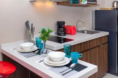 a kitchen with plates and utensils on a counter at LUMA Condo 1BR Open View NBC Nai Harn in Rawai Beach