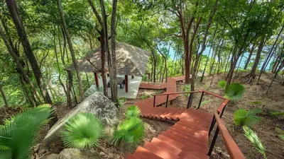 a wooden staircase leading to a house in the woods at Villa Chelay in Kamala Beach