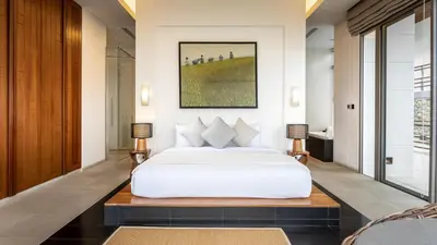 a bedroom with a white bed and two lamps at Villa Chelay in Kamala Beach