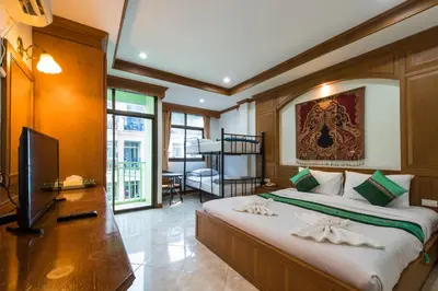 a bedroom with a large bed and a television at Magnific Patong in Patong Beach