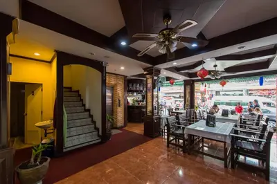 a restaurant with a table and chairs and a ceiling fan at Magnific Patong in Patong Beach