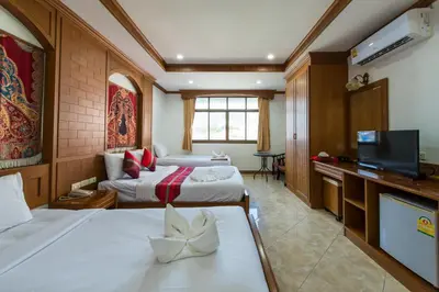 a hotel room with two beds and a flat screen tv at Magnific Patong in Patong Beach