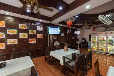 a restaurant with a dining room with tables and chairs at Magnific Patong in Patong Beach