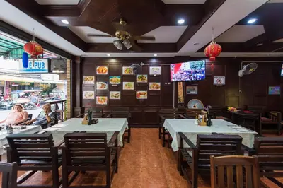 a dining room with tables and chairs in a restaurant at Magnific Patong in Patong Beach