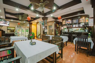 a restaurant with tables and chairs and a bar at Magnific Patong in Patong Beach