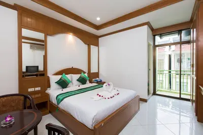 a bedroom with a bed and a table in a room at Magnific Patong in Patong Beach