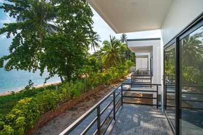 a view of the beach from the balcony of a house at Pine Bungalow Krabi in Klong Muang Beach
