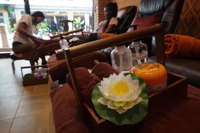 a table with a candle and a flower on it at Patong Mansion - SHA Certified in Patong Beach